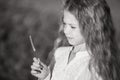 Black and white portrait of a beautiful child with long hair. Childhood in nature. A little girl holds a flower in her Royalty Free Stock Photo