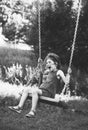 Black and white portrait of Beautiful little girl smiling on swing at summer day, Happy childhood concept. Soft focused