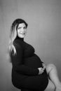 Black and white portrait of beautiful sitting pregnant woman posing Royalty Free Stock Photo