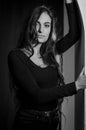 Black and white portrait of a beautiful young Italian woman with very long hair leaning against an arched wall, seductive Royalty Free Stock Photo