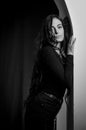 Black and white portrait of a beautiful young Italian woman with very long hair leaning against an arched wall, seductive attitude Royalty Free Stock Photo