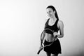 Black and white portrait of beautiful young woman player in sports clothes holding tennis racket Royalty Free Stock Photo