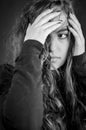 Black and white portrait of a beautiful young woman who tries to hide her face with her hands and go unnoticed Royalty Free Stock Photo