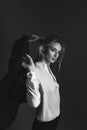 Black and white portrait of blonde girl in jacket and white shirt. Girl throws a jacket on her shoulders. Business portrait.