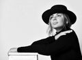 Black and white portrait of blonde dreaming girl in black hat with brim looking up at the sky on white Royalty Free Stock Photo