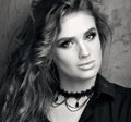 Black and white portrait of closeup up of a young woman in black shirt posing in front of a metal wall