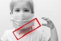 black and white portrait European child in medical mask with raised hand. red inscription in the frame `entry closed.` Royalty Free Stock Photo