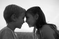Black and white portrait of girl and boy , looking at each other cutely, pressing their foreheads one to one Royalty Free Stock Photo