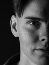 Black and white portrait of a handsome guy. Tired, sad young man on a black background. Stress concept. Royalty Free Stock Photo