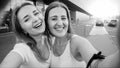 Black and white portrait of happy laughing female friends making selfie at shopping mall entrance Royalty Free Stock Photo