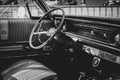 A black and white portrait of the interior of an oldtimer car. The steering wheel, dashboard and clutch are all visible of the Royalty Free Stock Photo