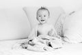 Black and white portrait of laughing baby sitting on bed after h Royalty Free Stock Photo