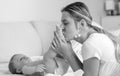 Black and white portrait of young mother kissing her baby son`s feet Royalty Free Stock Photo