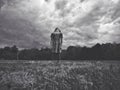 Black and white portrait of sad lonely little young girl standing in grass park with head thrown back in sky Royalty Free Stock Photo