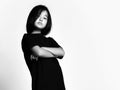 Black and white portrait of self-confident asian kid girl standing with her arms crossed at chest and looking at camera Royalty Free Stock Photo