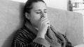 Black and white portrait of sick woman sitting in bed and using nasal spray Royalty Free Stock Photo