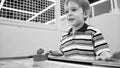 Black and white portrait of smiling excited boy playing air hockey at playroom in amusement park Royalty Free Stock Photo