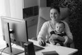 Black and white portrait of smiling mother sitting in office chair with her baby Royalty Free Stock Photo