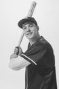 Black and white portrait of smiling young man, baseball player in uniform with bat preparing to hit ball. Student Royalty Free Stock Photo