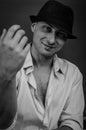 Black and white portrait of a smiling young man with a hat that rolls up his shirt sleeves Royalty Free Stock Photo