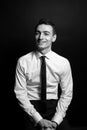 Black and white portrait of a smiling young man in a white shirt and black tie, looking at the camera Royalty Free Stock Photo