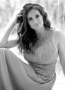 Black and white portrait of a stunning young girl sitting in a lavender color dress Royalty Free Stock Photo