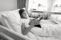 Black and white portrait of teenage girl lying in bed and using digital tablet computer Royalty Free Stock Photo