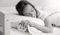 Black and white portrait of teenage girl sleeping and turning off ringing alarm clock Royalty Free Stock Photo