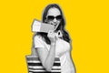 Black white portrait of a traveler girl walks with bag and passport, tickets with a yellow stroke Royalty Free Stock Photo