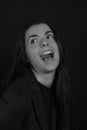 Black and white portrait of a young brunette woman in a studio on a black background