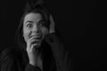 Black and white portrait of a young brunette woman in a studio on a black background