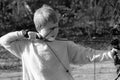 Black and white portrait of a young caucasian boy with a bow and arrow Royalty Free Stock Photo