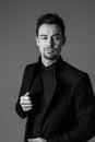 Black and white portrait of a young handsome man in a suit, hands on jacket Royalty Free Stock Photo