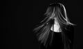 Black and white portrait of young happy woman with healthy restored long hair shaking her head to make her hair flying Royalty Free Stock Photo