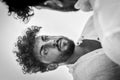 Black and white portrait of a young man with a beard and curly hair looking at himself in an horizontal mirror Royalty Free Stock Photo