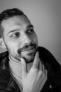 Black and white portrait of a young man touching his chin in a moment of inspiration Royalty Free Stock Photo