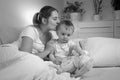 Black and white portrait of young mother kissing her baby son before going to sleep Royalty Free Stock Photo
