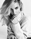 Black and white portrait of young sexy flirting blonde woman vamp in warm knitted sweater looking at camera Royalty Free Stock Photo