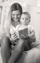 Black and white portrait of young mother reading story to her baby boy Royalty Free Stock Photo