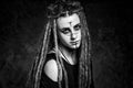 Black and white portrait of a young woman with dreadlocks against dark background Royalty Free Stock Photo