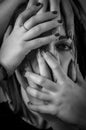 Black and white portrait of a young woman with her face covered with hands, concept for showing the anxieties and fears of women