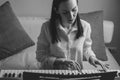 Black and white portrait of a young woman learning to play electronic piano