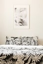Black and white poster above bed with patterned cushions in mini
