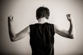 Black and white rear view of teen flexing biceps Royalty Free Stock Photo