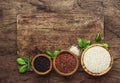 Black, white and red quinoa in spoons, raw quinoa groats assorted, wooden rustic kitchen table, top view Royalty Free Stock Photo