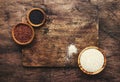 Black, white and red quinoa in spoons, raw quinoa groats assorted, wooden rustic kitchen table, top view Royalty Free Stock Photo