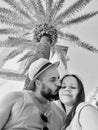 Black and white selfie of a romantic couple kissing under palmtree in Positano, Italy