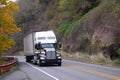 Black and white Semi truck reefer trailer on autumn highway Royalty Free Stock Photo