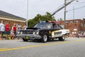 A black and white Sheriff car driving through the fourth of July parade