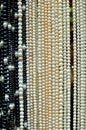 Black and white shiny pearl necklaces hanging at market for sle Royalty Free Stock Photo